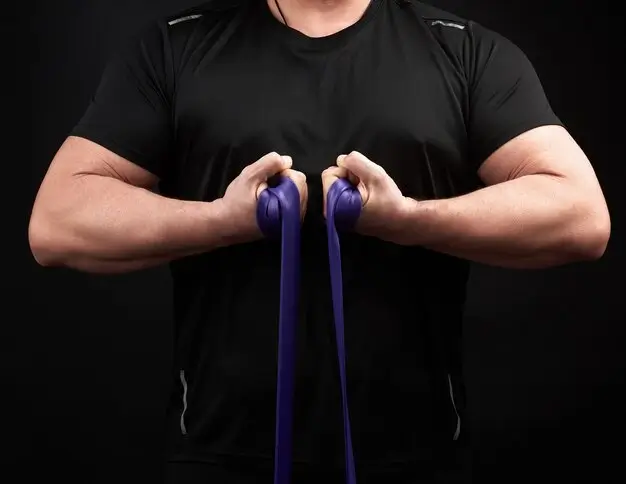 A man demonstrating resistance bands vs weights with a strong grip on a resistance band.